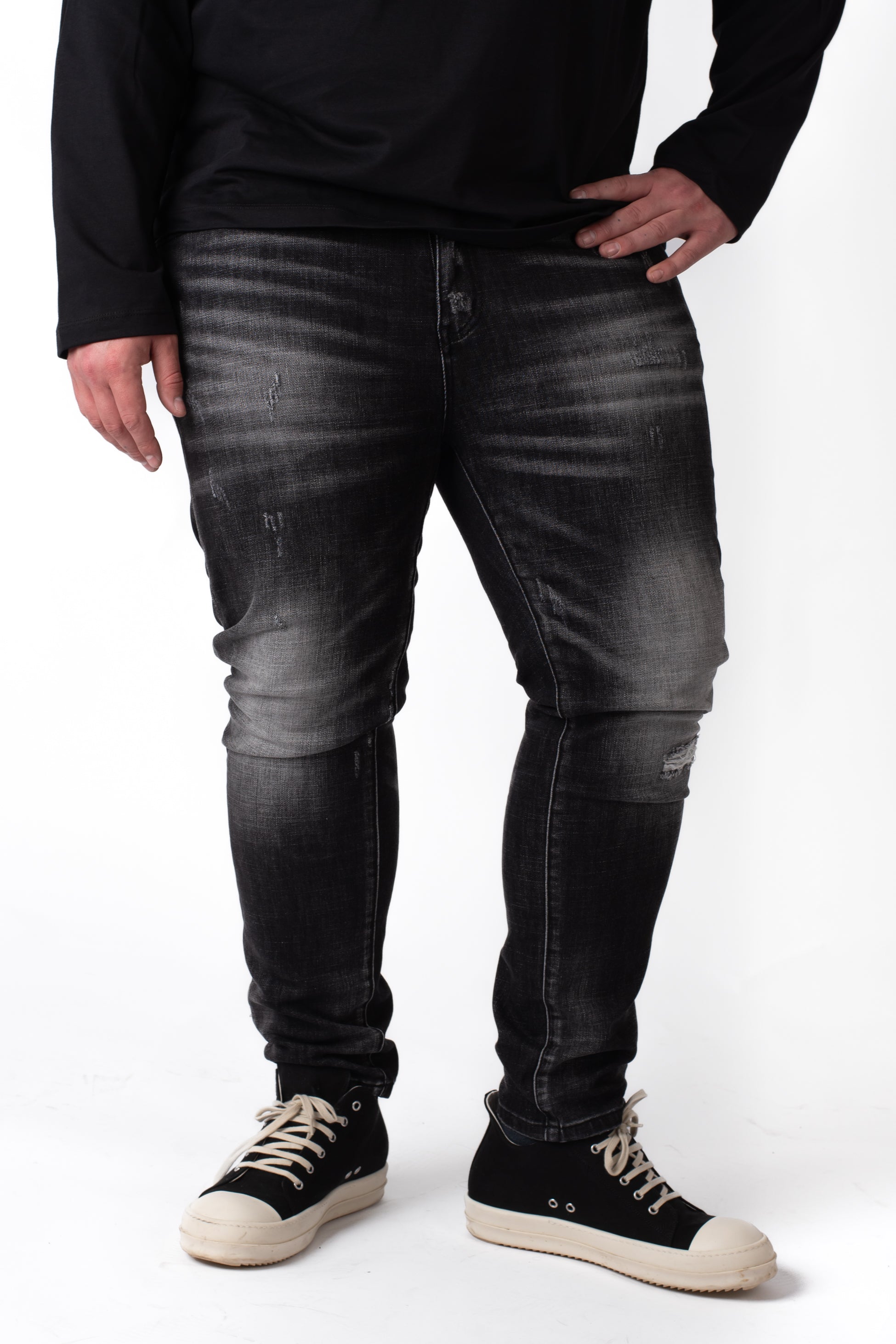 Jeans neri washed effetto used con abrasioni taglie forti uomo con sneakers